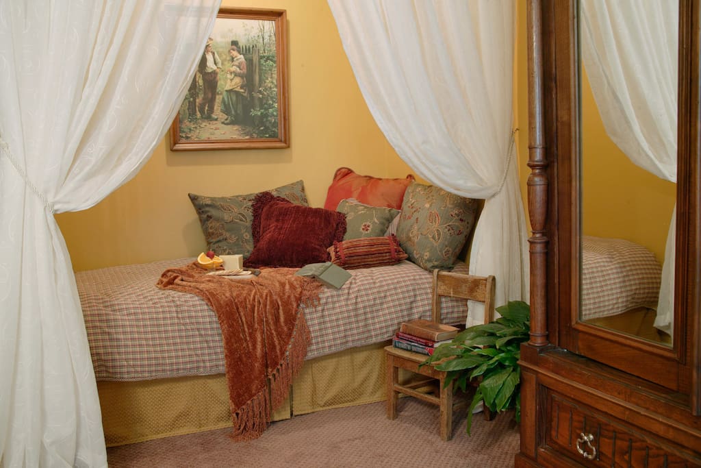 Twin bed tucked away in alcove.