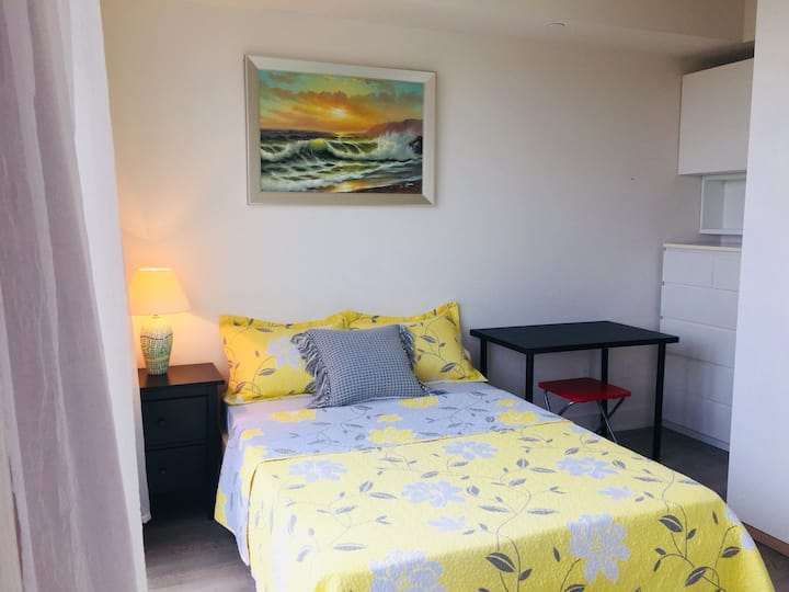 חדר שינה ראשי שליו עם פינת עבודה ייעודית.