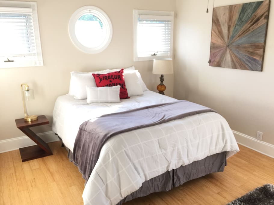 The bright and airy upstairs bedroom has a ceiling fan and lots of windows.