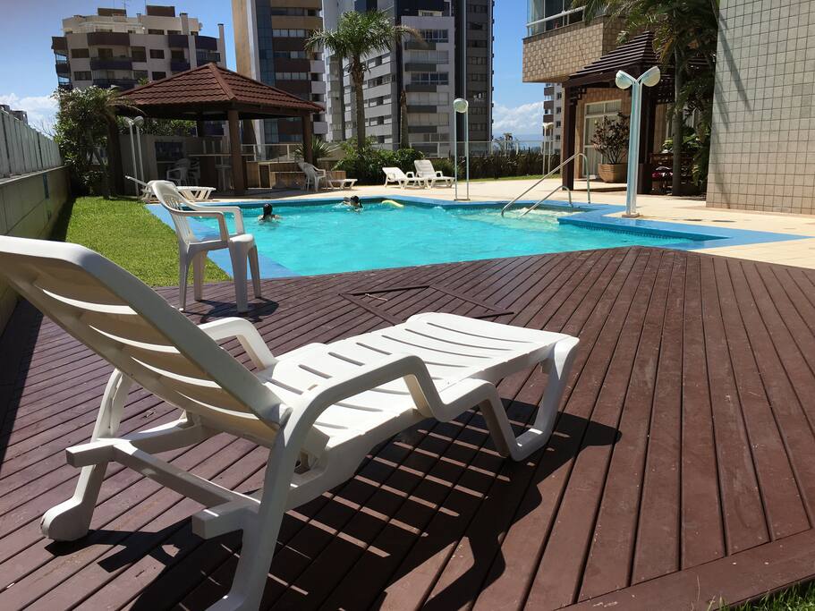 A área da piscina no 2º andar, cercada por pérgolas, jardim, vestiário, sauna, academia, VIP Lounge, salão de jogos e playground.