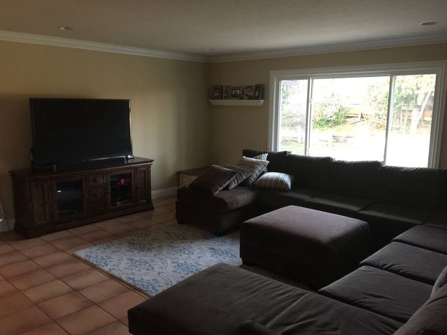 Living Room with enormous 9 person sectional and 60 inch flat screen TV (with full cable package)
