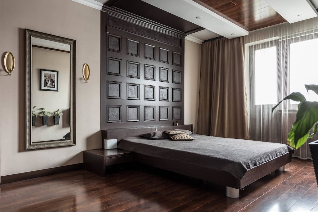 Bedroom, view from the entrance: 6.5 foot bed with chocolate headboard and large mirror.
Спальня, вид со входа: двухметровая кровать с шоколадным изголовьем и большое зеркало.