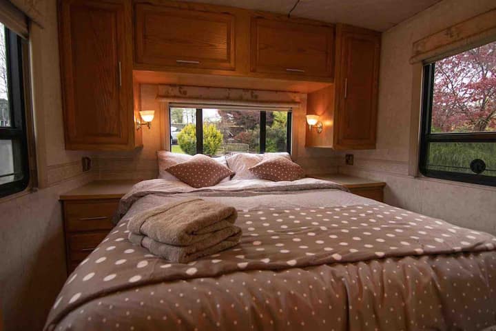 Cosy Bedroom in RV with comfy King sized bed, and views of the back garden and surrounding countryside.