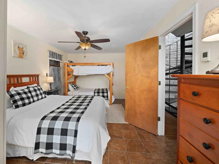 Lower level bedroom with a queen bed and two twin beds in a bunk bed.