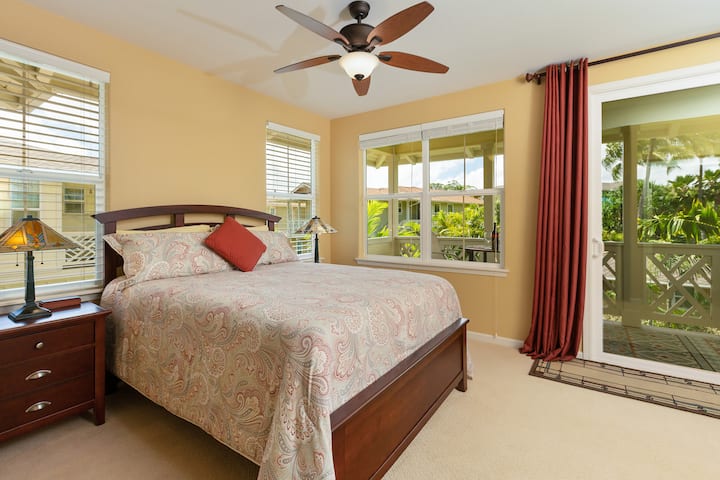 Relax in the light-filled third bedroom, featuring a plush queen bed and direct access to a private lanai with pool and mountain views.