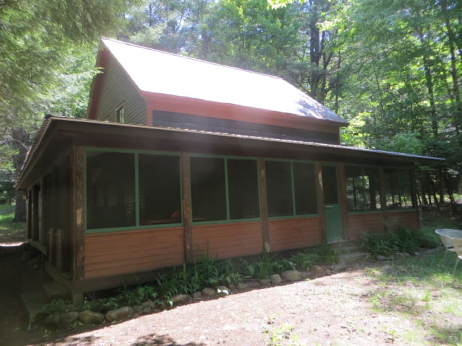 The screened-in porch seen from the lawn at the back of the house.