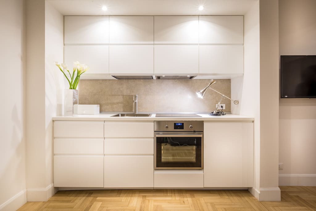 Cucina moderna completamente attrezzata con lavabo, frigo, lavastoviglie, piano cottura ad induzione, forno elettrico, macchina caffè Nespresso.
