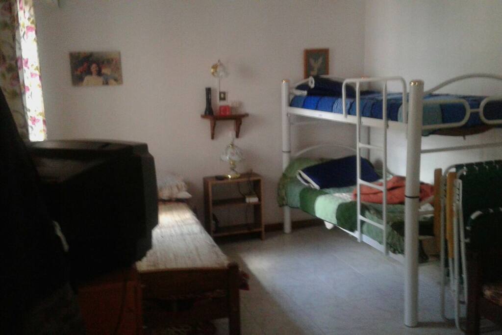 Habitación con 3 camas individuales + 1 corricama. Hay otro cuarto con una cama matrimonial. Total 5/6 personas cómodas.