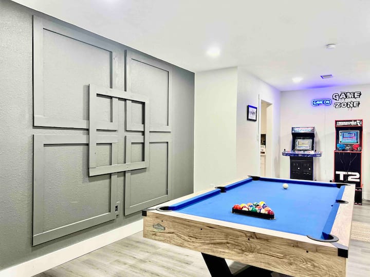 Sala de juegos que incluye mesa de billar y juegos de arcade