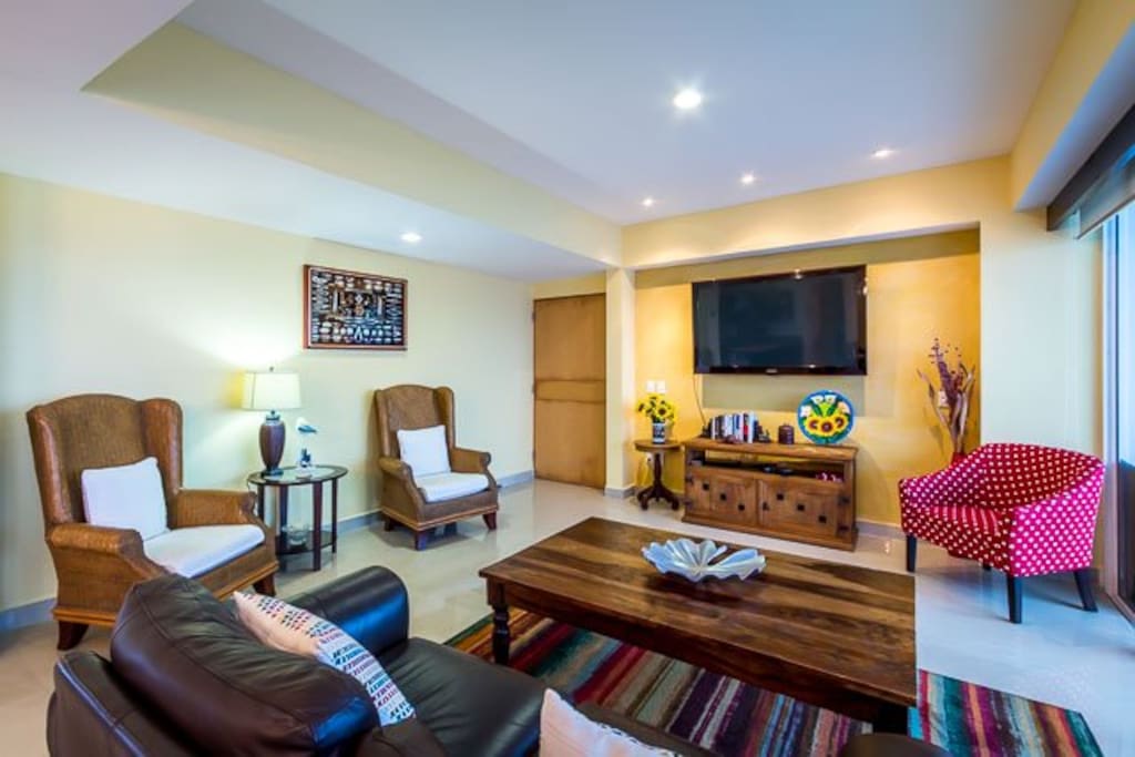 Living room has comfortable seating and a 50 inch TV with cable