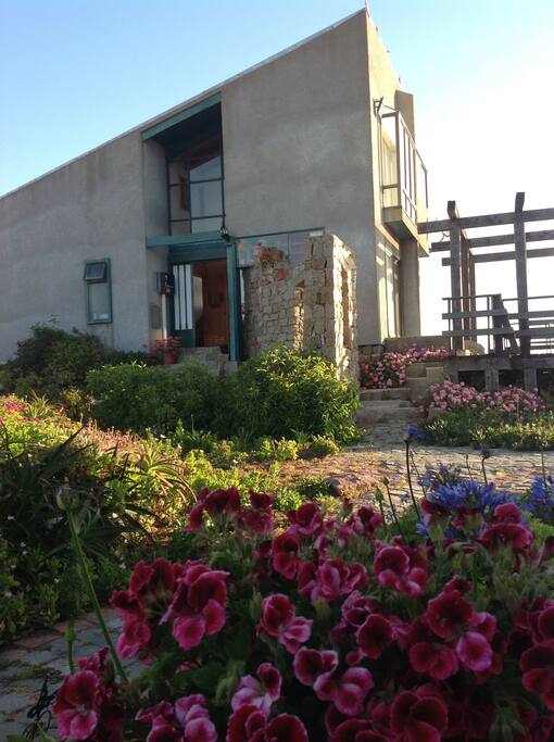 La Casa Gris es de 2 pisos, de 100 metros2, ubicada en primera línea frente a playa Isla Negra y con vista a Casa de Pablo Neruda, en condominio con guardia 24 horas y alarma de seguridad. Tiene 4 dormitorios, Living, Comedor, Cocina, 3 baños, terraza exterior frente a piscina, acogedor quincho y con entrada de auto. La casa está 100% equipada para disfrutar de unos agradables días en Isla Negra.