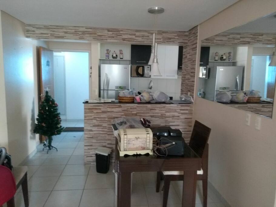 porta de entrada, parte da cozinha com balcão americano e sala