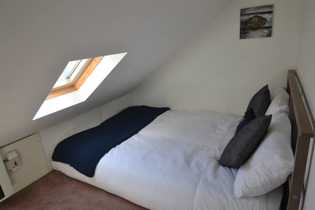 Double bed tucked in on the mezzanine floor.