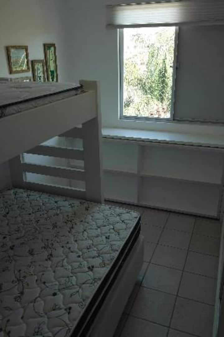 Quarto com cama de casal e duas de solteiro