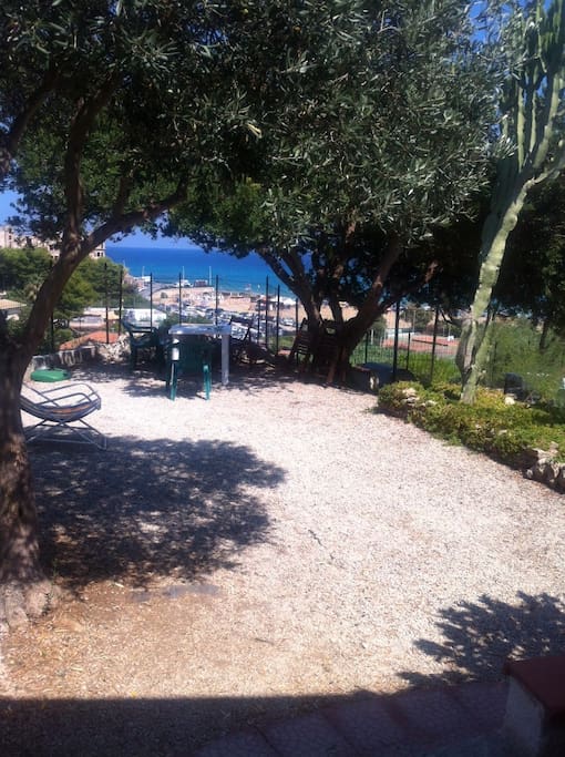 un posto relax attrezzato sotto l'enorme chioma di un lentisco e con magnifica vista mare ( la zona gode sempre del venticello marino)