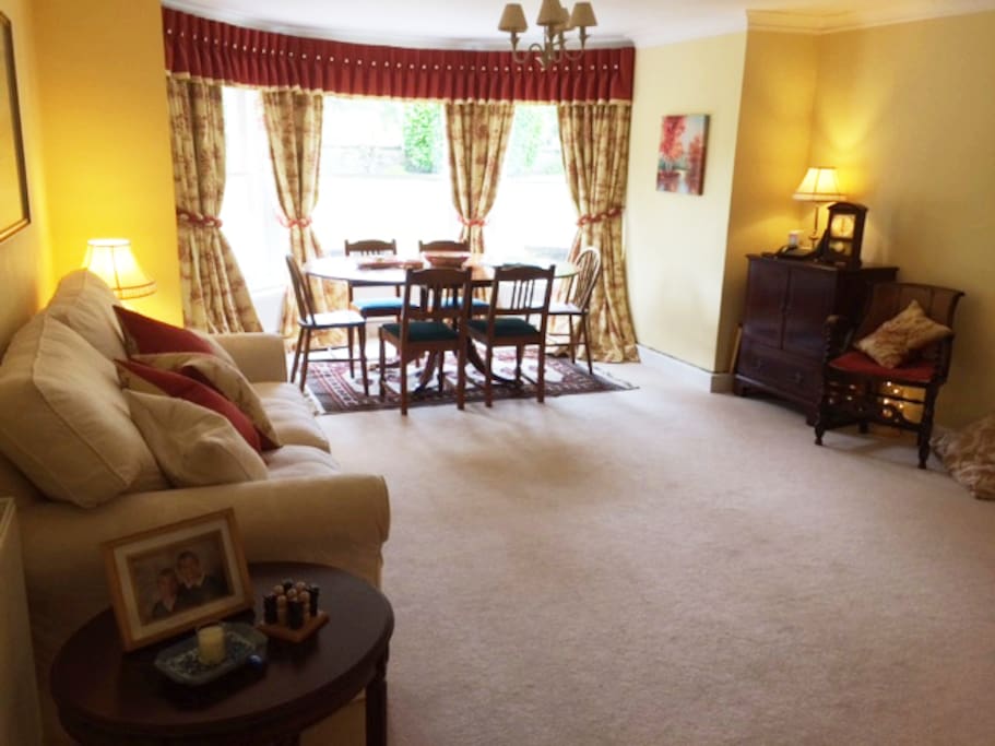 Large Sitting Room with sofa-bed, dining area and bay-window over-looking garden.