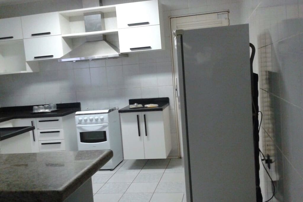 Cozinha ampla e arejada é equipada com fogão 4 bocas, coifa, geladeira, armários e bancadas espaçosas.