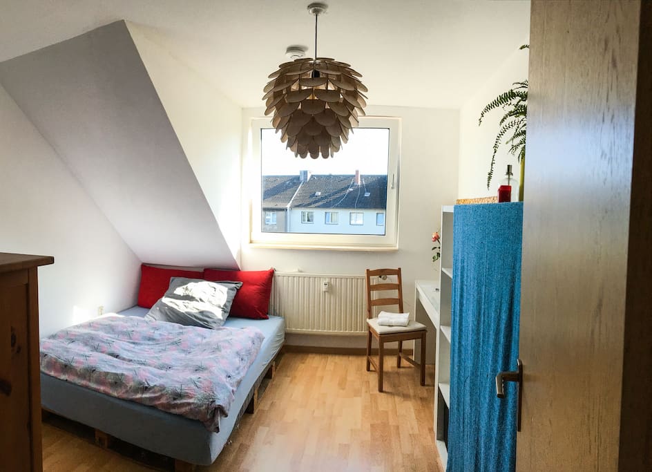 Neben dem weichen Bett findest du Sitzmöglichkeiten und einen Tisch, der zum Arbeiten geeignet ist.