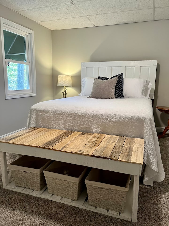 Este dormitorio de invitados tiene un nuevo colchón queen de primera línea. Está ubicado en el nivel inferior de salida. Hay un baño completo a la vuelta de la puerta. ¡También hay una bonita ventana con vistas al lago!