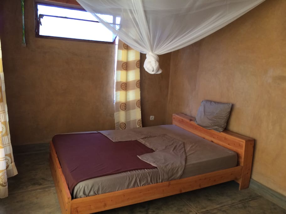 Bedroom 1 - All rooms have queen-sized beds with linens and mosquito nets with closet rods and shelves.
