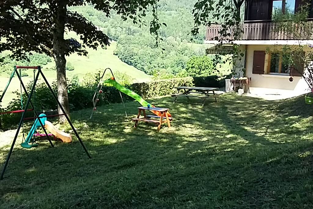 Jardin en jouissance aménagé pour les enfants, table et barbecue pour profiter des belles journées