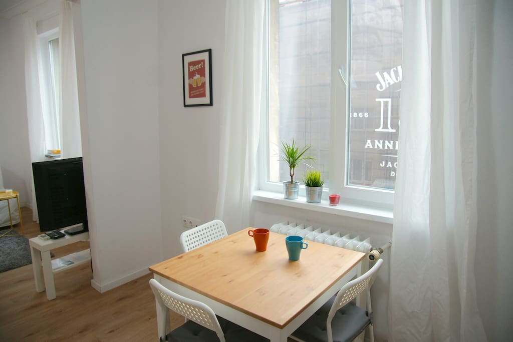 Kitchen with a small dining table, fridge, oven, hotplate, coffee machine, toaster