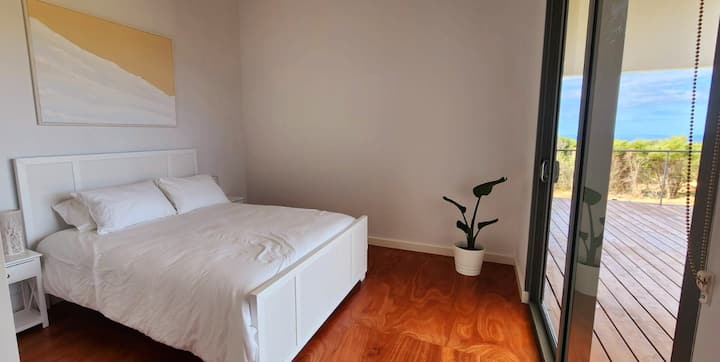 Guest bedroom 3 with Queen size bed. 
Native bushland views and ocean glimpses