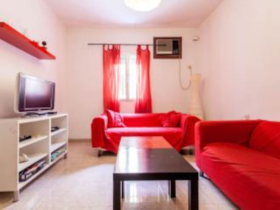 salon con tv ,aire acondicionado ,mesa comedor y sofa cama