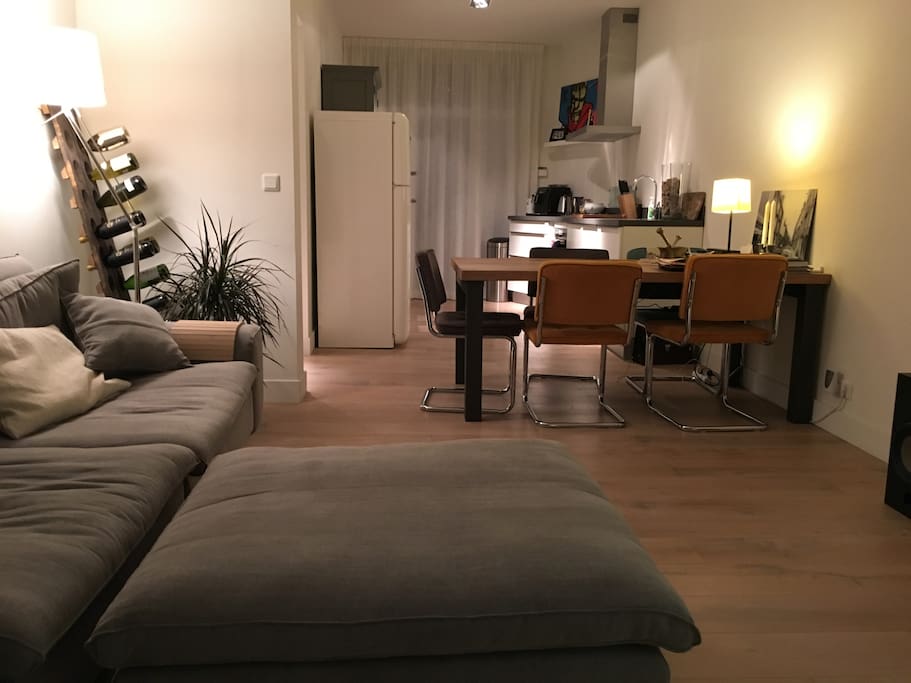 At night. Livingroom with kitchen in the back, with the balcony behind the curtains (NW)
