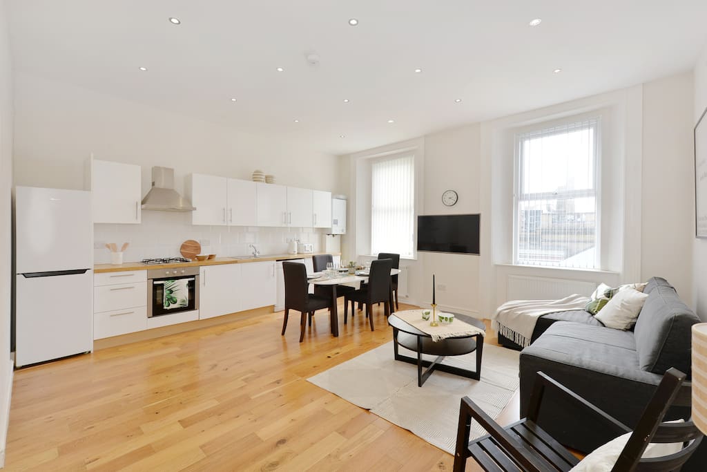 The spacious Living Room with sofa bed, dining table and chairs and well-equipped kitchen