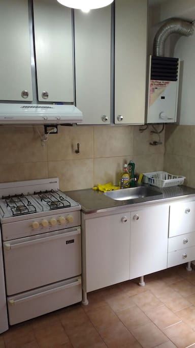 Cocina con alacenas + bajo mesada, extractor y calefón.