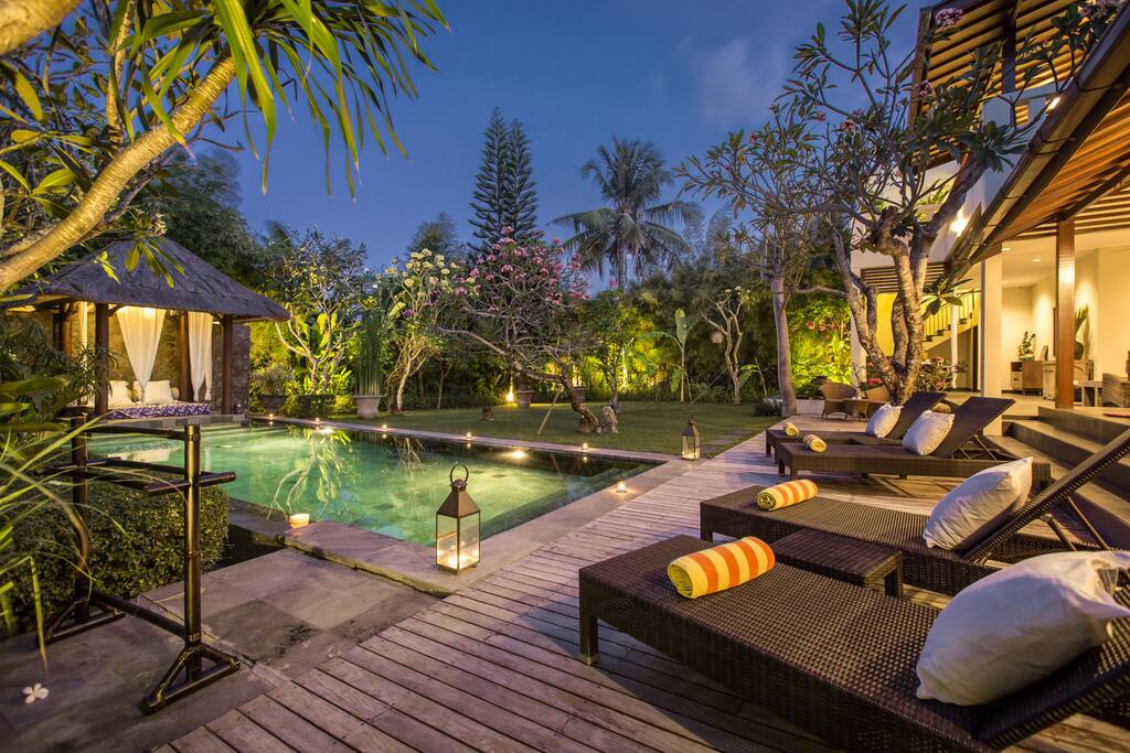 Pool and sun loungers by night