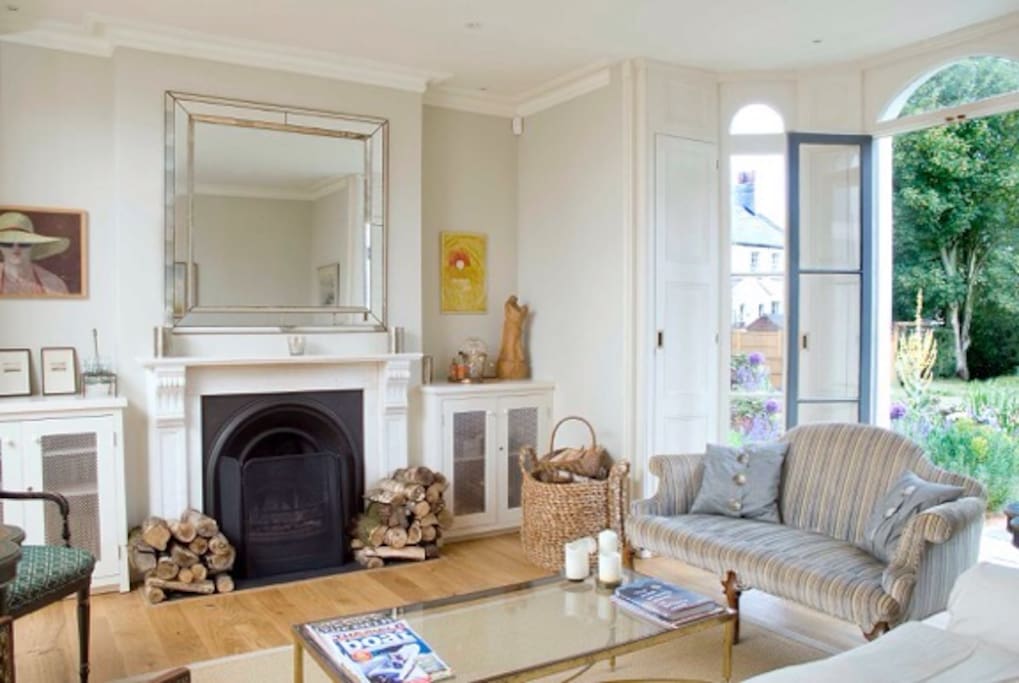 Open plan sitting room with French doors leading to front garden with bench view next photo. Music ceiling speakers.