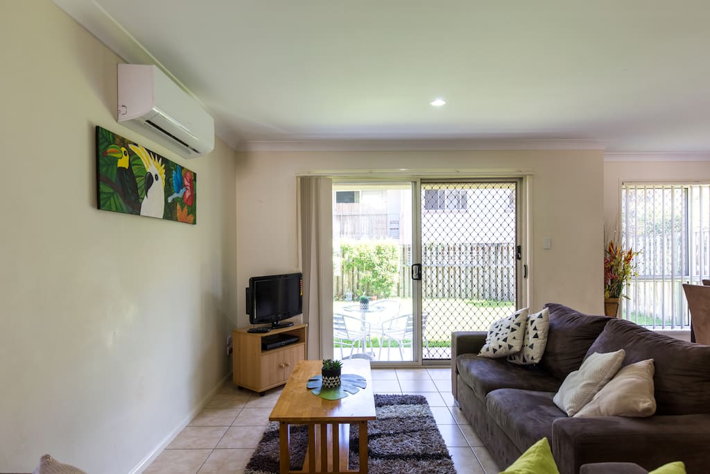 Open plan living glass doors leading out to patio BBQ and grassy area for children to play