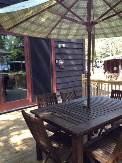 It includes a spacious deck with grill and dining table with a view of the lake