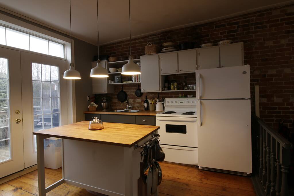 Full kitchen with french doors to a deck with a BBQ.