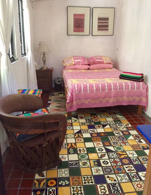 A small bedroom that's bright and airy with lots of windows. Comfortable mattress on a double bed.