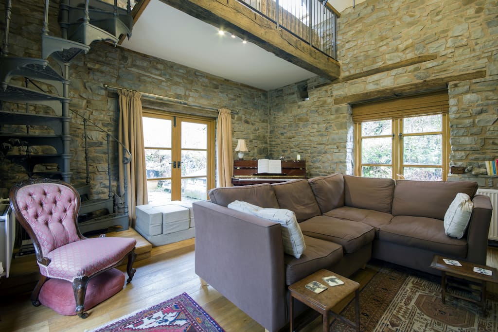 Living room or old Mill room. It has a mezzanine where there are two extra beds if needed. The French windows lead to a terrace which has access to the river and gardens.