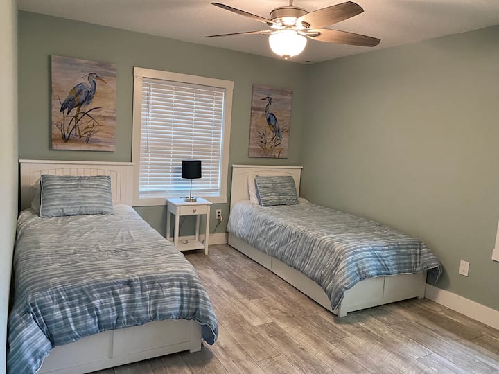 Dormitorio de invitados en la planta superior con dos camas individuales y una cama nido. 