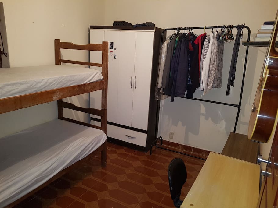Quarto com beliche, cabides, mesa e guarda roupa