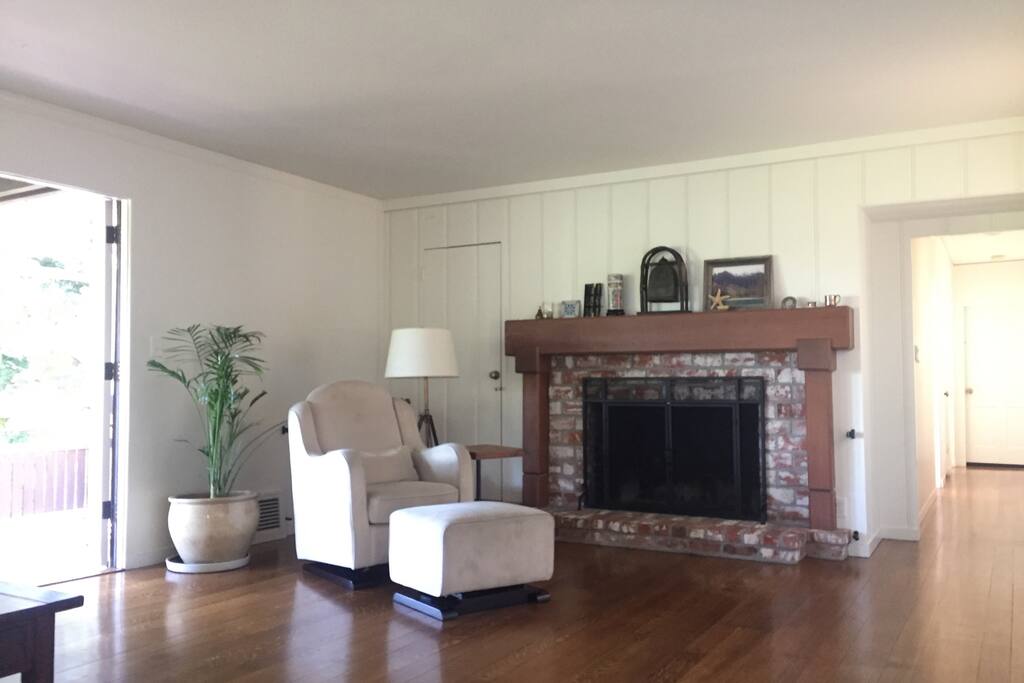 Another view of the living room with large fireplace and hall to the bedroom wing