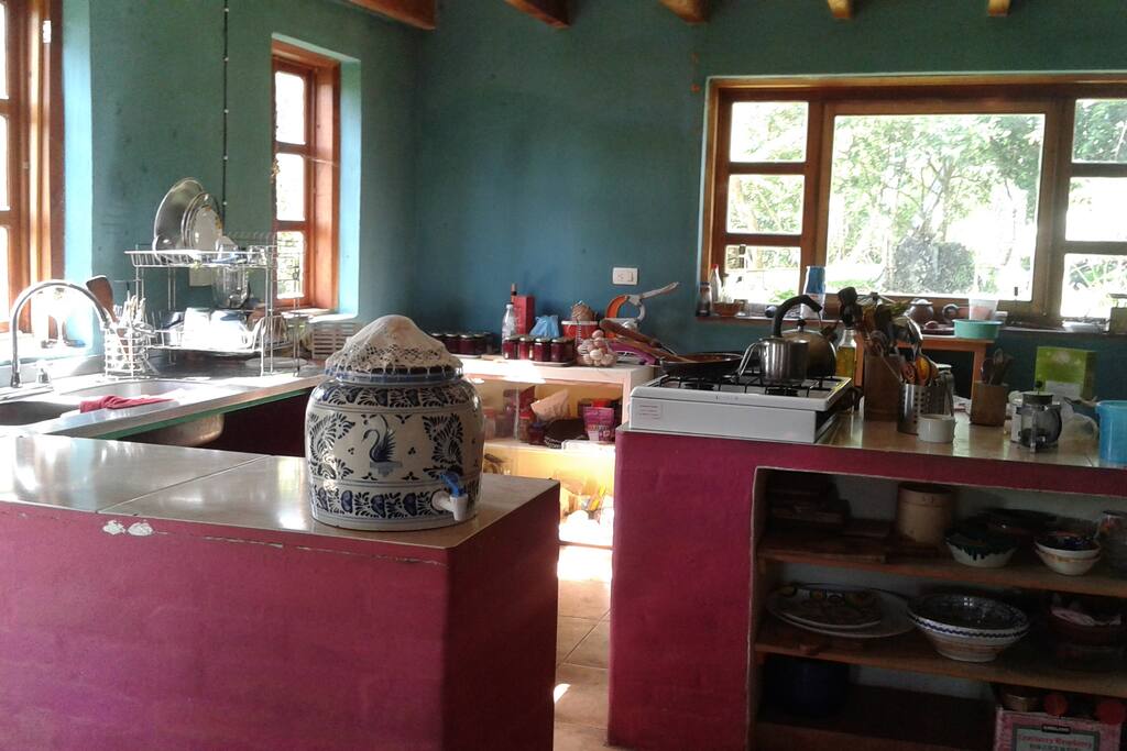 Cocina con ecotecnias, estufa-horno de leña que incluye calentador de agua para la ducha. Estufa de gas.