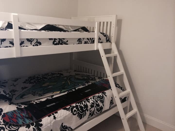 غرفة نوم ثانية تضم سريرين وتلفزيون وخزانة ملابس