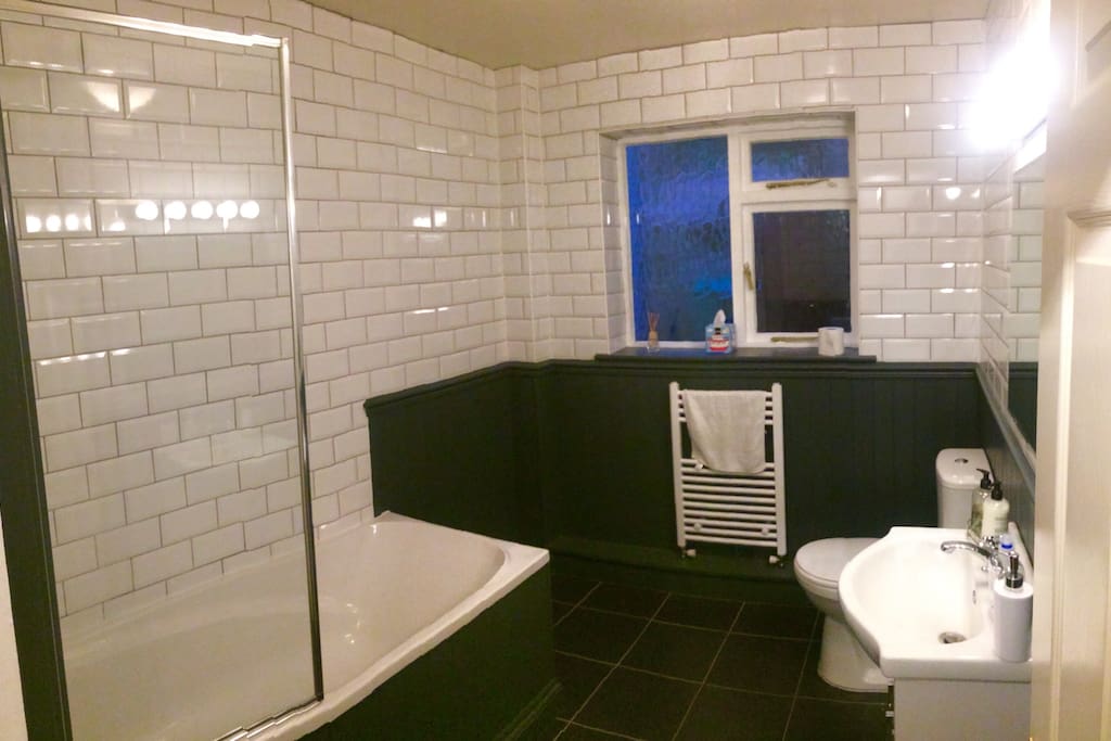 Modern bathroom, bath and electric shower.