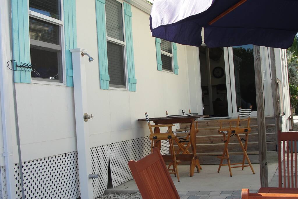 Outdoor shower with plenty of outdoor seating with shade.