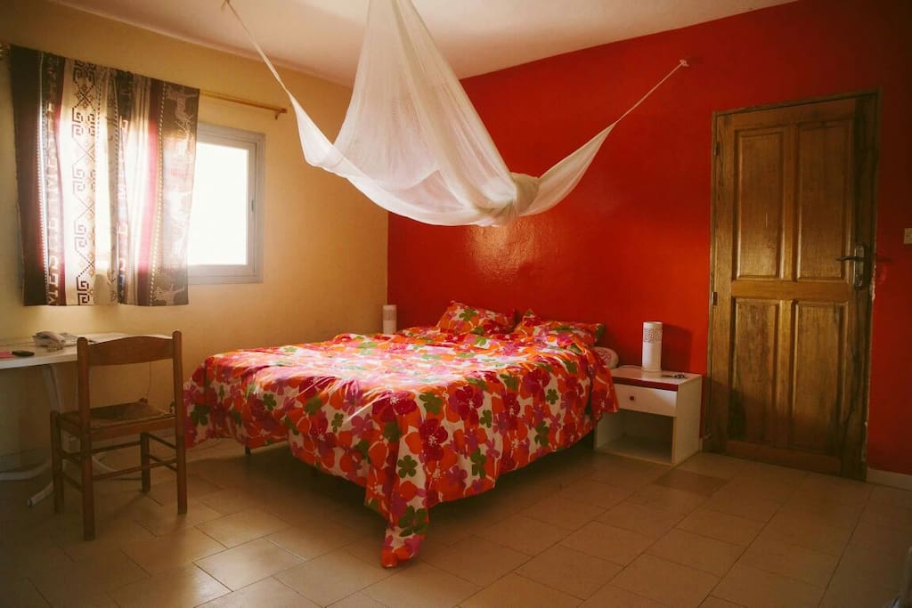 the master room, with a large bed, desk and mosquito net.