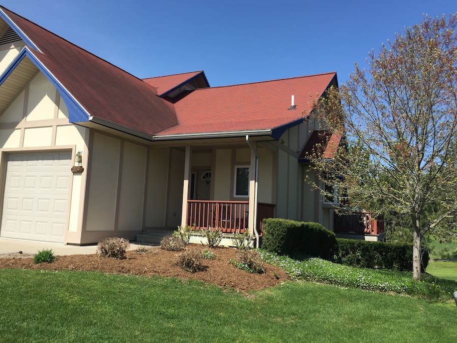 Front view of condo. Front porch with small sitting area. Large driveway with plenty of room to park cars.
