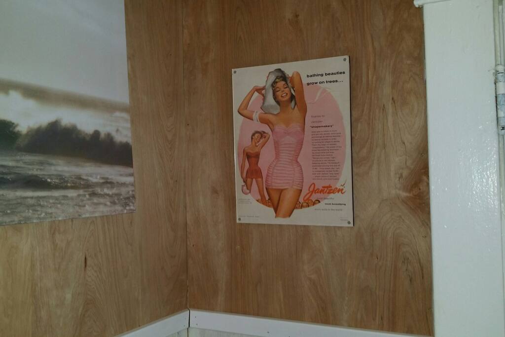 Vintage swimwear ads add a touch of whimsy to the beach themed decor.