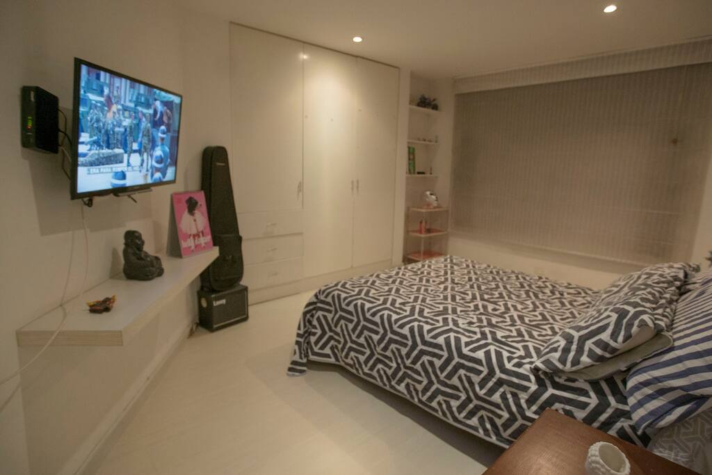 A room equipated with a double bed, tv, closet and private bathroom