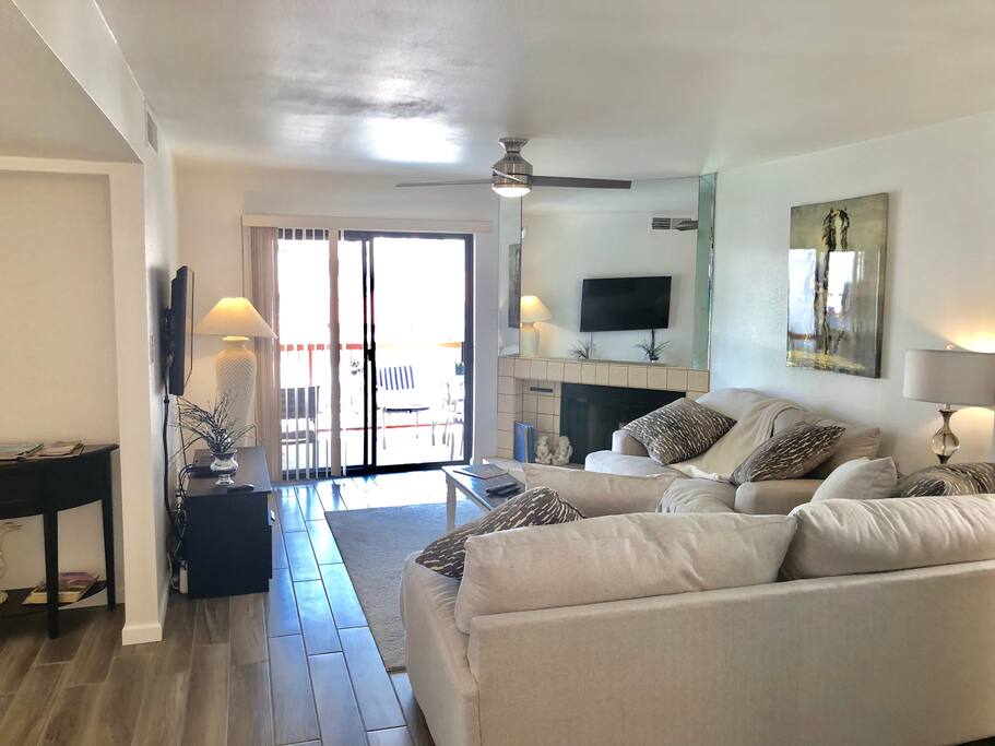 Family room sitting area. New upgrades in 2017 include couch television tile flooring light fixtures and more. Sliding glass door leads to balcony overlooking the pool